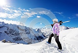 Confident ski girl stand on top of the mountain