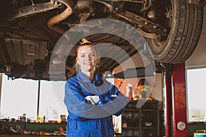 Confident smiling auto mechanic woman in overalls