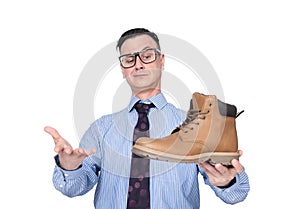 Confident smiling businessman in a shirt, tie and glasses demonstrates a shoe in his hand to a buyer, isolated on white background