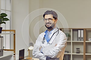 Confident smiling doctor posing with arms crossed in hospital