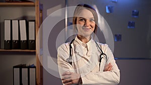 Confident smiling female doctor posing in the hospital during night shift.