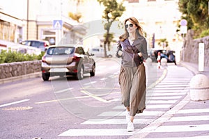 Confident smiling middle aged woman walking on the stret