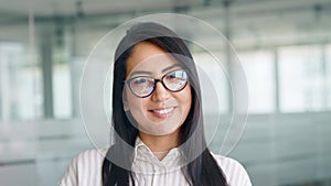 Confident smiling young Asian business woman in office, headshot portrait.