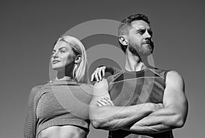 confident sport couple in sportswear relax on sky background, fitness