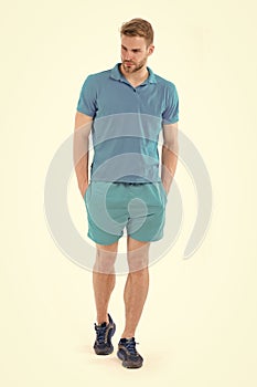 Confident sportsman. Full length handsome fit man in blue sports clothing and sneakers isolated white background