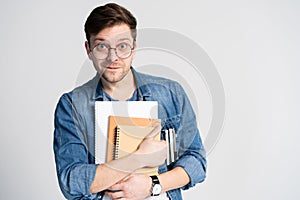 Confident student. Studio portrait of handsome young man holding books. Isolated on white.