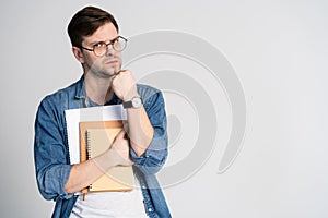 Confident student. Studio portrait of handsome young man holding books. Isolated on white.