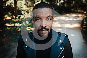 Confident stylish african american man wearing black leather jacket outdoor. Street wear fashion black man