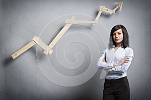 Confident successful businesswoman in front of positive trend chart.