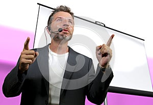 Confident successful man with headset speaking at corporate business coaching and training auditorium conference room talking