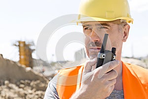 Confident supervisor using walkie-talkie at construction site