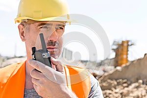 Confident supervisor using walkie-talkie at construction site