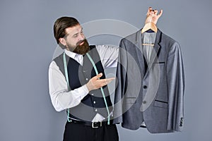 Confident tailor designing male jacket. handsome sartor with tape measure. male beauty and fashion. bearded man