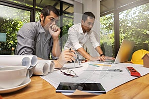 Confident team of architect working together in a office. They discussing about new startup project on desk.