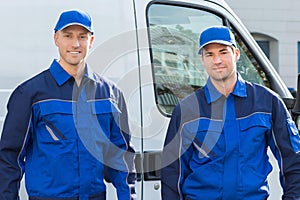 Confident Technicians Standing Against Truck