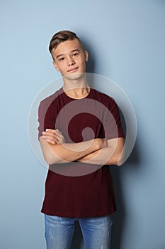 Confident teenage boy on color background