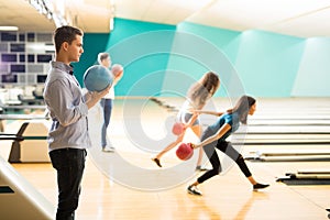 Confident Teenage Boy With Friends Bowling In Club