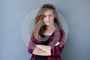 Confident teenage girl standing with arms crossed