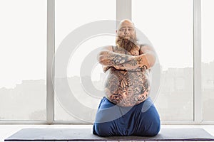 Confident thick guy doing meditation