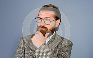 Confident thoughtful businessman in suit with hand on chin making decision, feeling doubt. Serious handsome bearded man