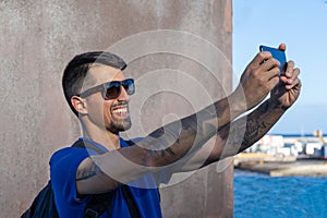 Confident traveler taking a selfie with his camera