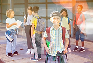 Confident tweenager posing near school during break between lessons