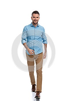 Confident unshaved man in casual outfit walking and smiling