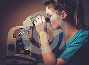 Confident veterinarian examining the test under the microscope in Veterinary clinic.