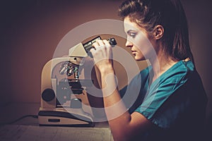 Confident veterinarian examining the test under the microscope in Veterinary clinic.