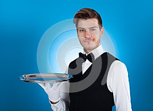 Confident waiter carrying tray