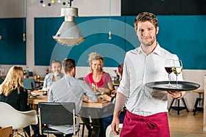 Confident Waiter Holding Tray At Restaurant