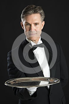 Confident Waiter In Tuxedo Carrying Serving Tray