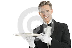 Confident Waiter In Tuxedo Holding Serving Tray