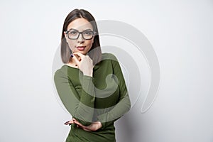 Confident woman in glasses with hand on chin