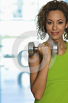 Confident Woman Lifting Dumbbell In Club