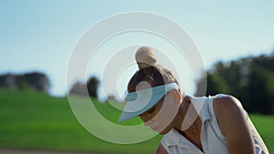 Confident woman playing golf on fairway. Golfer swinging ball at country club.