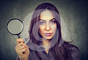 Confident woman posing with magnifier