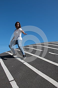 Confident woman posing over asphalt floor with white stripes photo