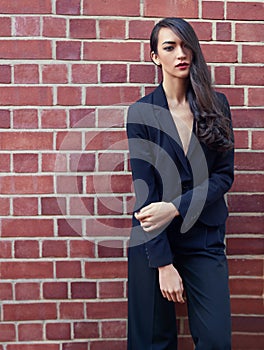 Confident woman, power suit and fashion with hair on brick wall background, pride and makeup with lipstick. Glamour