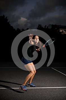 confident woman with racket ready to hit tennis ball.