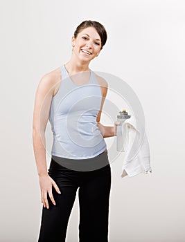 Confident woman in sportswear holding towel