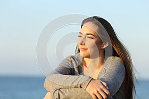 Confident woman watching sunset on the beach