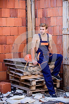 Confident worker. professional repairman hard hat fittings. man builder in work clothes. building and construction