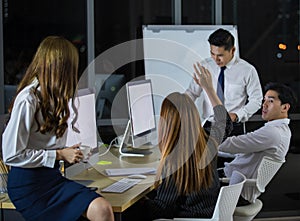 Confident young adult Asian businessman leader presenting work to colleagues in the meeting to brainstorm an idea to solve the