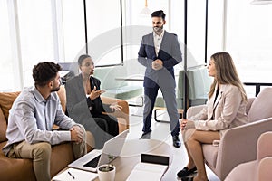 Confident young African business professional woman talking to diverse team