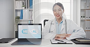 Confident young Asia female doctor in white medical uniform with stethoscope looking at camera and showing laptop computer in