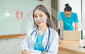 Confident young Asia female doctor in white medical uniform with stethoscope looking at camera and smiling  health hospital.