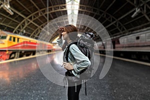 Confident young Asian backpacker woman looking new challenges at train station. Summer travel vacations lifestyles