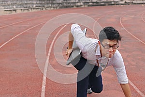 Confident young Asian business man with laptop ready start position to forward on race track.