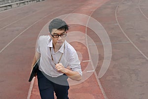 Confident young Asian businessman with laptop ready run to forward on race track. Business vision concept.